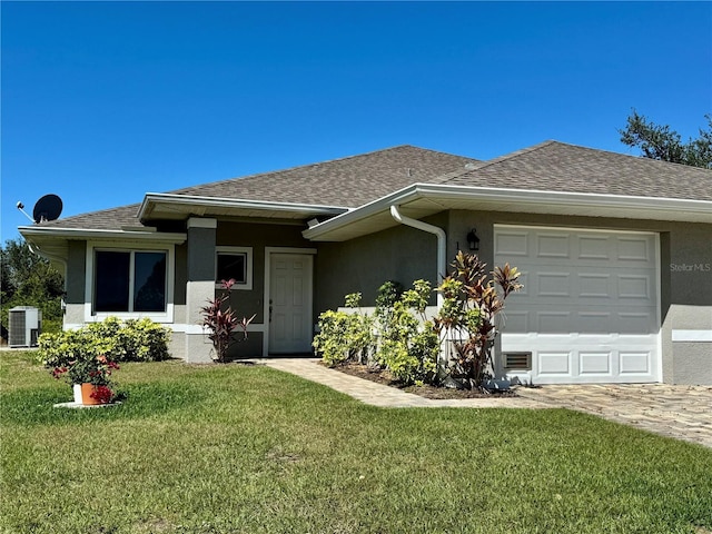 ranch-style house with stucco siding, central air condition unit, a front yard, and a shingled roof