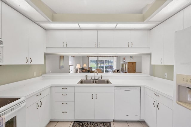 kitchen with white appliances, light tile patterned floors, light countertops, and a sink