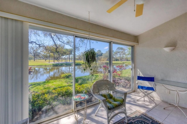 sunroom / solarium featuring plenty of natural light, a water view, and a ceiling fan