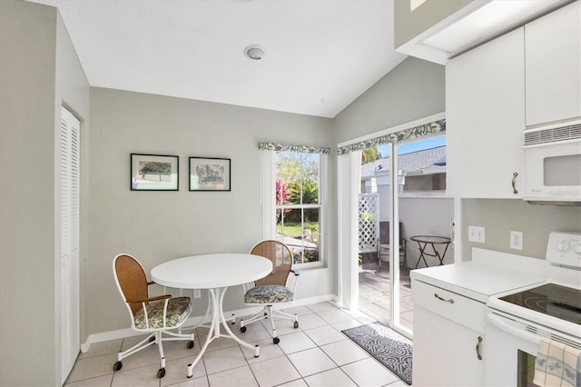 dining room featuring vaulted ceiling, light tile patterned flooring, and baseboards