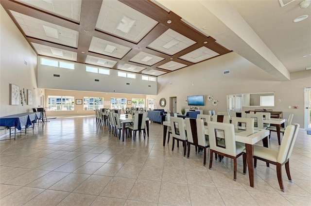 dining space featuring visible vents, coffered ceiling, a towering ceiling, and light tile patterned floors