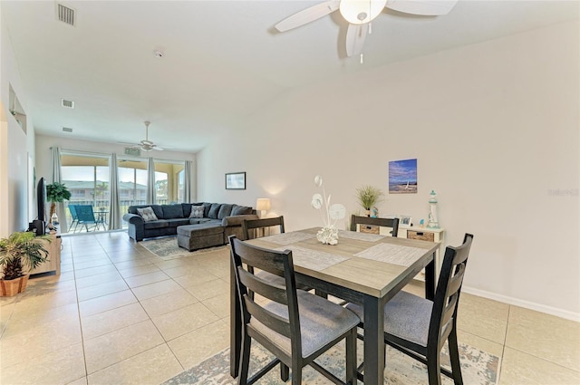 dining space featuring light tile patterned floors, vaulted ceiling, visible vents, and baseboards