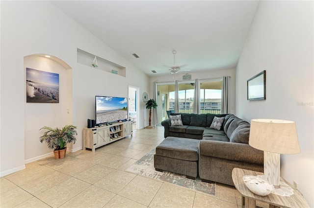 living area with ceiling fan, high vaulted ceiling, light tile patterned floors, and baseboards