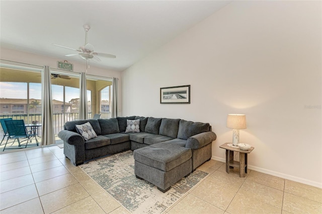 living area with ceiling fan, vaulted ceiling, baseboards, and light tile patterned floors