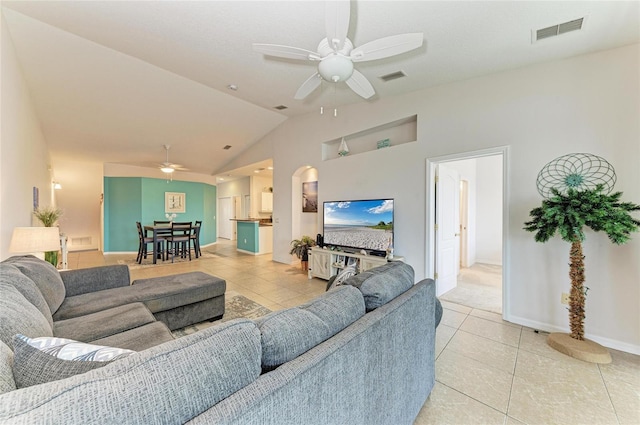 living room featuring vaulted ceiling, visible vents, ceiling fan, and light tile patterned flooring