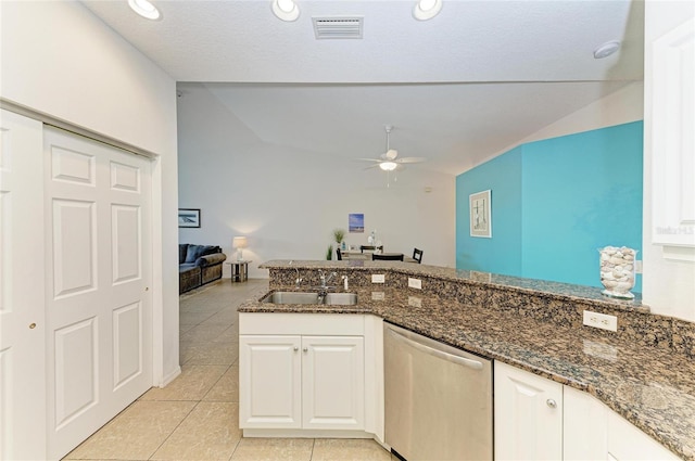 kitchen featuring visible vents, vaulted ceiling, ceiling fan, dark stone counters, and dishwasher