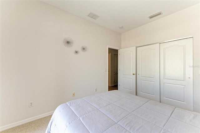 bedroom with carpet floors, a closet, visible vents, and baseboards