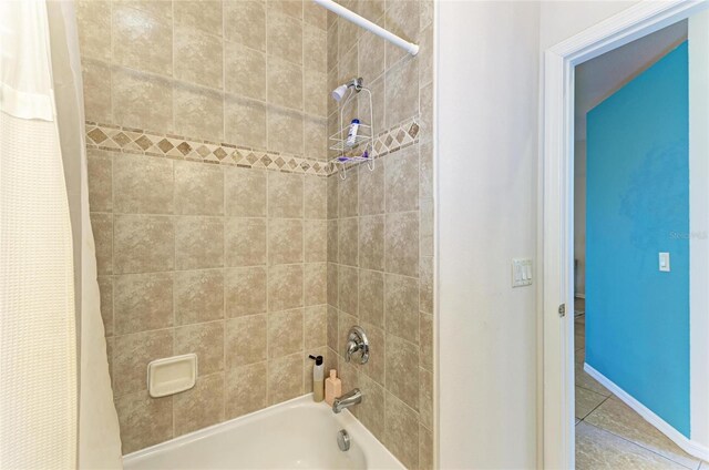 full bath with shower / tub combo, tile patterned flooring, and baseboards