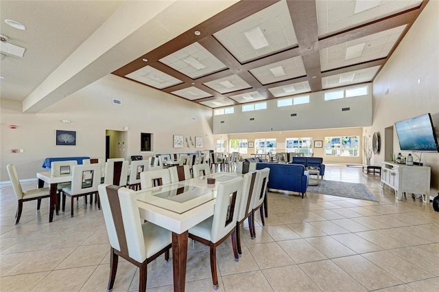 dining room featuring light tile patterned floors, a high ceiling, coffered ceiling, and baseboards