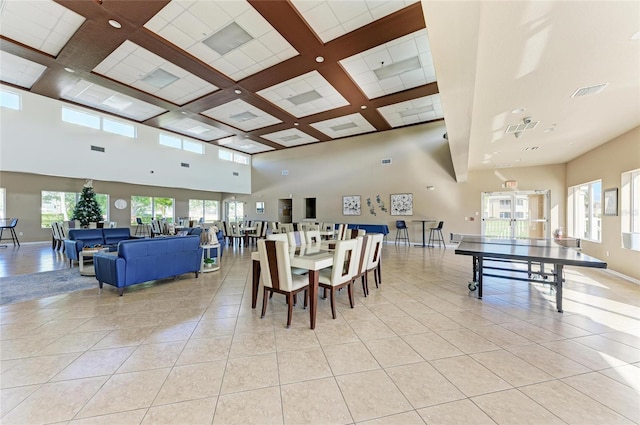 dining area with light tile patterned floors, coffered ceiling, visible vents, a towering ceiling, and baseboards