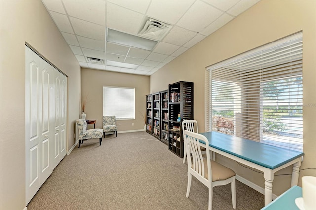 carpeted office space featuring a paneled ceiling, visible vents, and baseboards