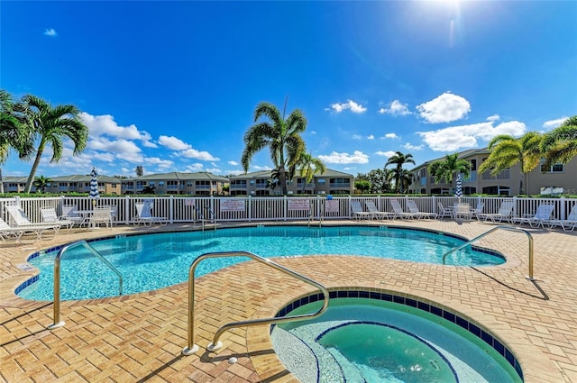 pool featuring a residential view, fence, a community hot tub, and a patio