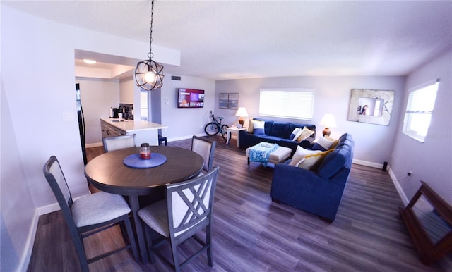 dining space with visible vents, baseboards, and dark wood-style floors