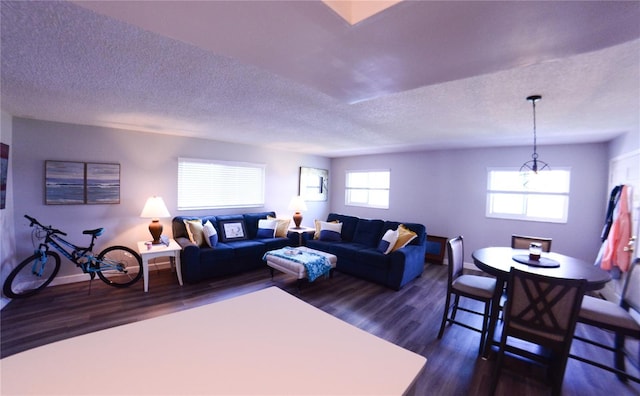 living area with dark wood finished floors, baseboards, and a textured ceiling