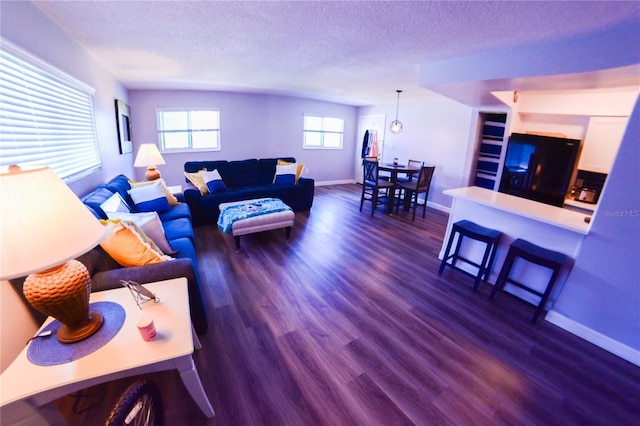 living area featuring dark wood finished floors, a textured ceiling, and baseboards