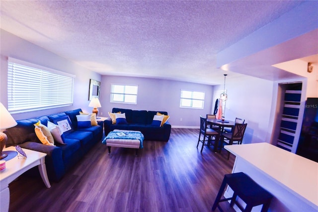 living area featuring dark wood finished floors, a textured ceiling, and baseboards