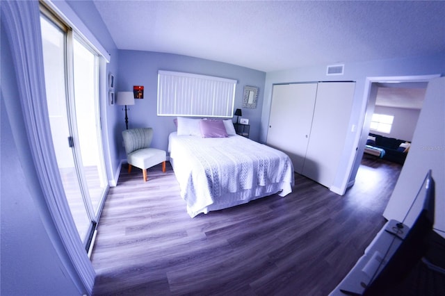 unfurnished bedroom featuring visible vents, a closet, and wood finished floors