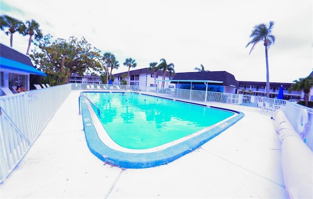 community pool with a patio and fence