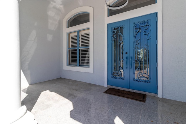 property entrance with french doors and stucco siding