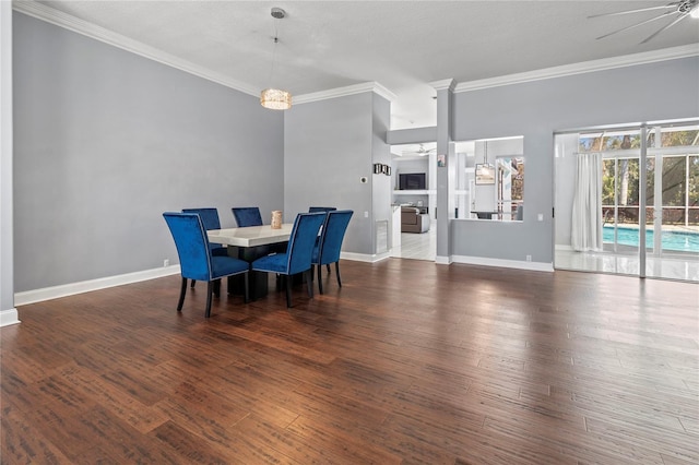 dining space with baseboards, ornamental molding, wood finished floors, and ceiling fan with notable chandelier