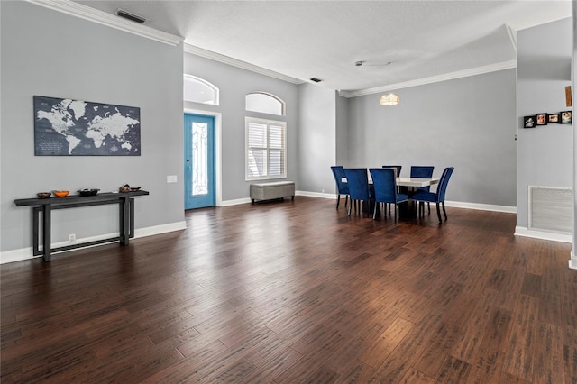 dining space featuring baseboards, visible vents, wood finished floors, and ornamental molding