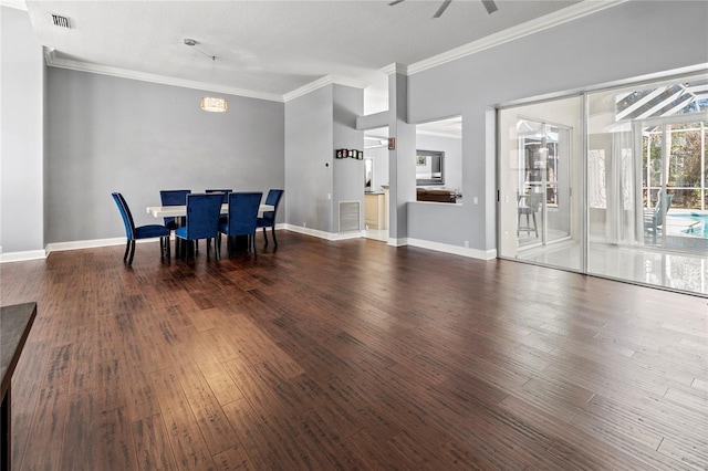 dining room with dark wood-style floors, visible vents, and crown molding