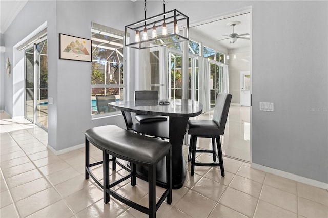 dining area with a sunroom, light tile patterned flooring, and baseboards