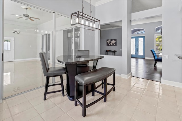 dining area featuring ornamental molding, french doors, light tile patterned floors, and baseboards