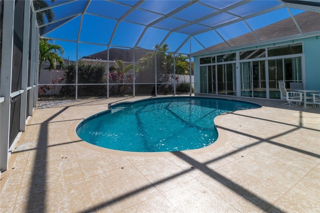 view of swimming pool with a lanai, fence, a fenced in pool, and a patio