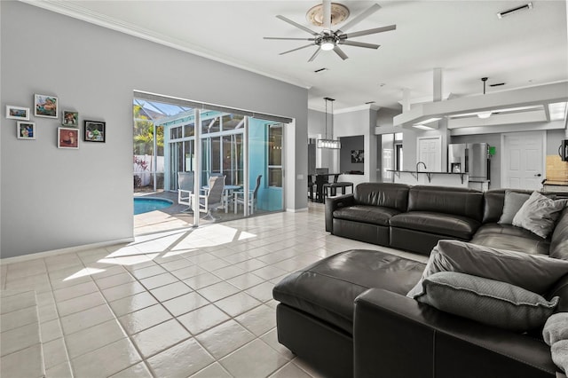 living room with light tile patterned floors, baseboards, visible vents, a ceiling fan, and ornamental molding