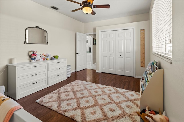 bedroom with a ceiling fan, a closet, visible vents, and dark wood finished floors