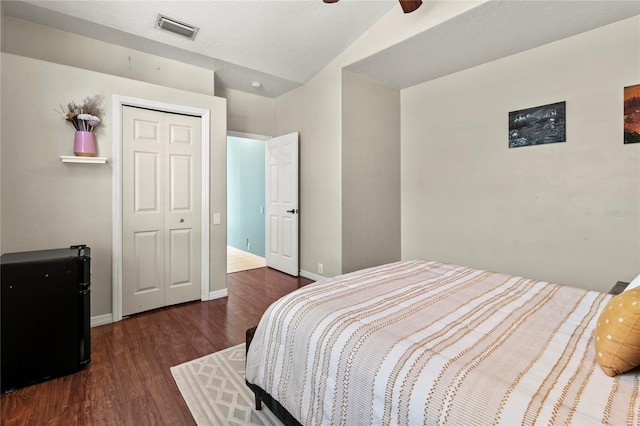 bedroom with baseboards, a closet, visible vents, and wood finished floors