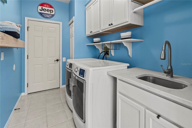 washroom featuring cabinet space, light tile patterned floors, baseboards, independent washer and dryer, and a sink