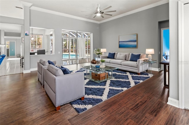 living area with a ceiling fan, baseboards, ornamental molding, and wood finished floors