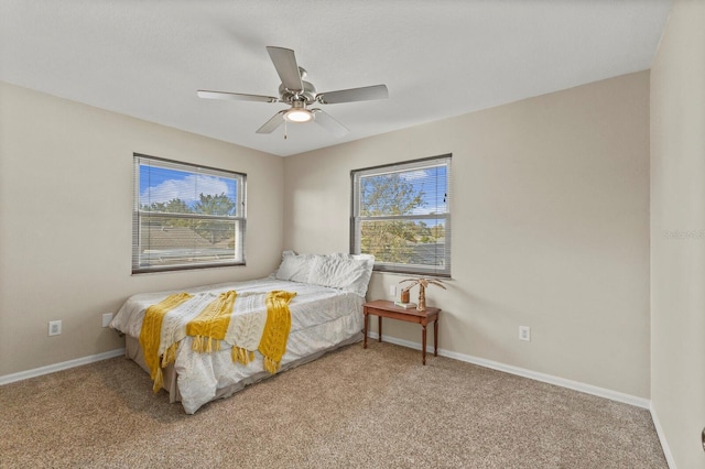 carpeted bedroom with multiple windows, ceiling fan, and baseboards