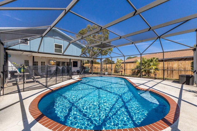 view of pool featuring a fenced in pool, glass enclosure, a patio area, and a fenced backyard