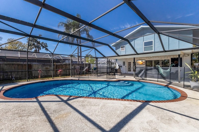 view of swimming pool featuring glass enclosure, french doors, a patio area, and fence