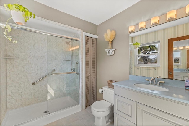 bathroom featuring a stall shower, toilet, tile patterned floors, vanity, and a closet