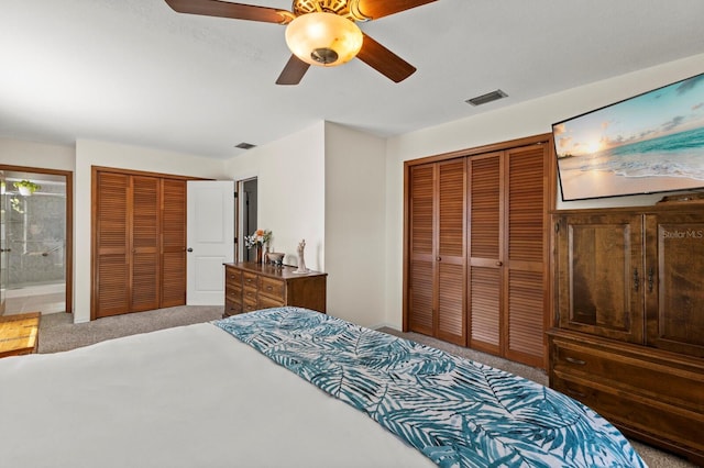 carpeted bedroom featuring visible vents, ceiling fan, and two closets