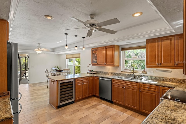 kitchen featuring beverage cooler, stainless steel appliances, a tray ceiling, and a peninsula