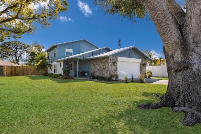 view of front of house with a garage, fence, concrete driveway, stone siding, and a front lawn