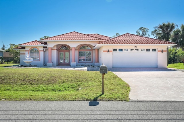 mediterranean / spanish-style house featuring driveway, an attached garage, a front lawn, french doors, and a tile roof