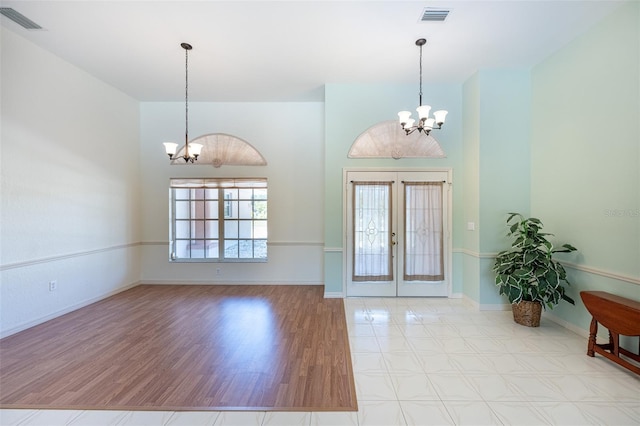 foyer with visible vents, baseboards, and an inviting chandelier