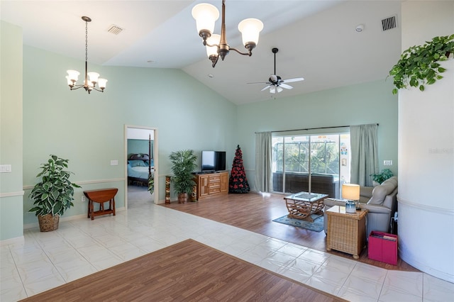 living area with visible vents, ceiling fan with notable chandelier, high vaulted ceiling, and baseboards