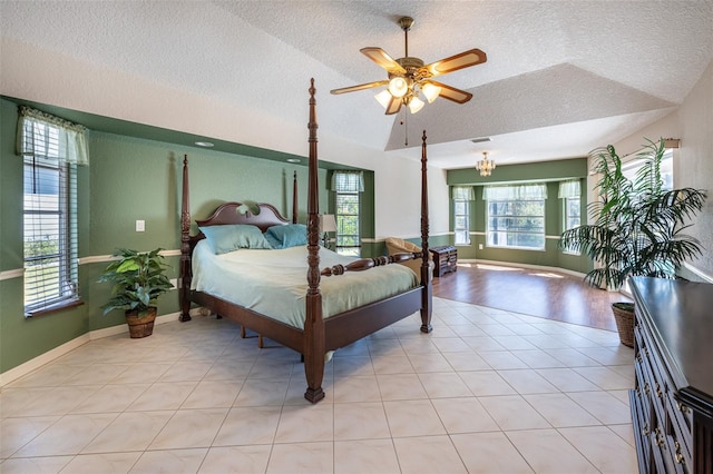 bedroom featuring lofted ceiling, baseboards, and a textured ceiling