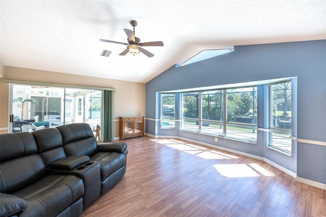 living room featuring visible vents, baseboards, vaulted ceiling, wood finished floors, and a ceiling fan