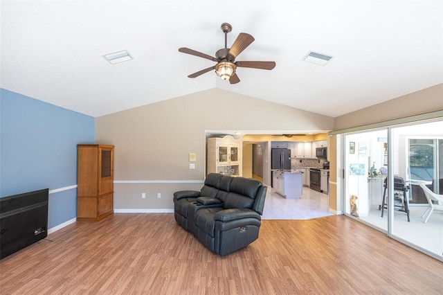 sitting room with visible vents, lofted ceiling, light wood-style flooring, and a ceiling fan