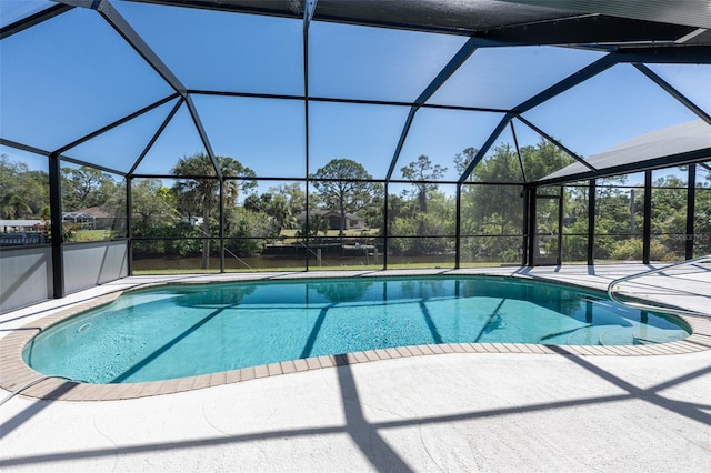 pool featuring glass enclosure and a patio area