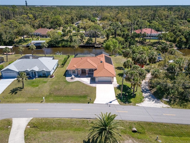 birds eye view of property featuring a forest view and a water view