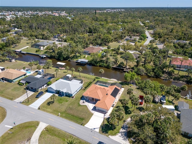 drone / aerial view with a forest view, a residential view, and a water view